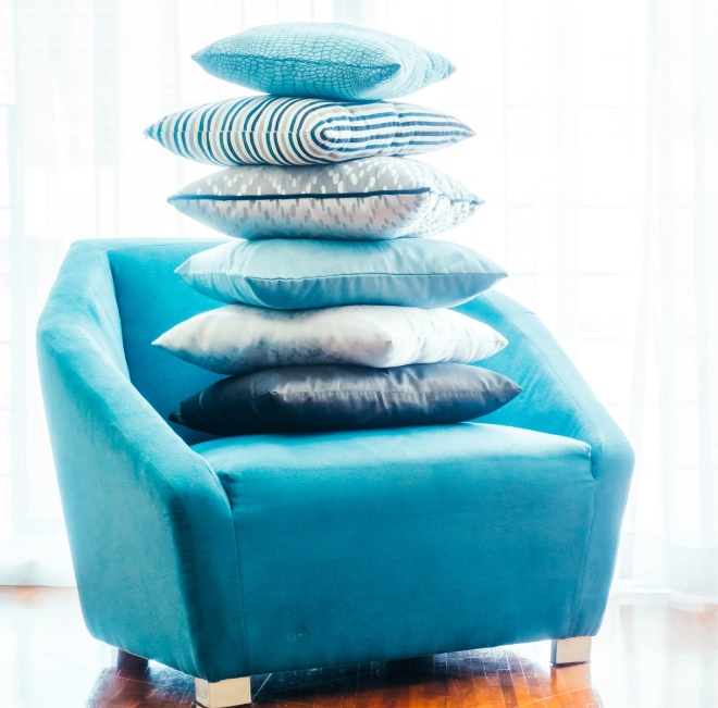 Blue armchair with colorful pillows.