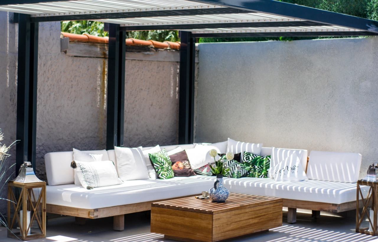 White patio furniture under pergola.