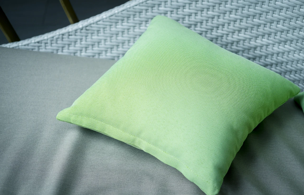 Green pillow on grey patio furniture.